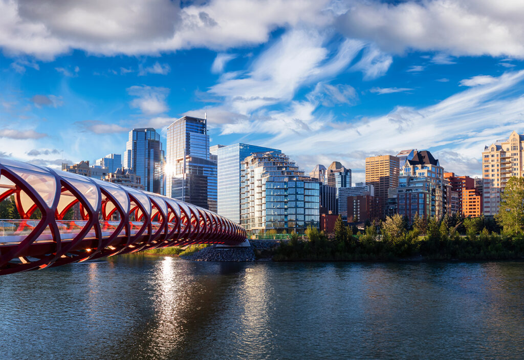 Peace Bridge across Bow River during a vibrant summer sunrise. Urban Downtown City Skyline. Taken in Calgary, Alberta, Canada.